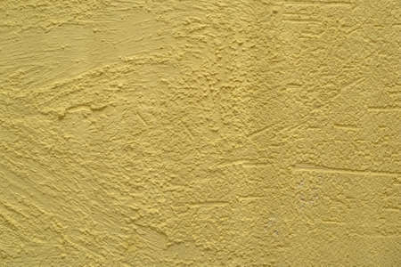 Decorative stucco background with textured sand with rough ragged edges yellow dirty colorの写真素材