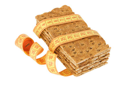 Several crispbread pieces with measuring tape isolated on whiteの写真素材