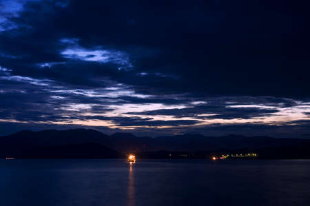 Dramatic thunderstorm clouds over sea late at nightの写真素材
