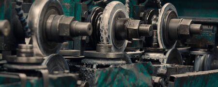 Industrial steel roll coil for metal profile forming machine in metalwork factory workshop. The main working bodies of the machine, metal rolls. Concept for metalwork production. Close up. Selective focus.の写真素材