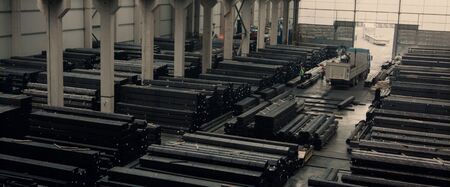 Interior of production department in modern plant at an heavy industrial factory . Employees in helmet operating a metal processing machines that manufacture sheet metal for further processing in metalworking company. Concept for metalwork and manufacturing.の写真素材
