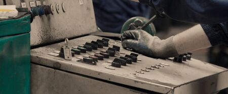 Industrial worker operating machine on control panel in metal industry. Concept for metalwork...