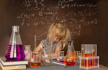 Curious little girl with test tubes and colorful substances makes tests at school laboratory. Small kid learning chemistry and conducts science experiment on biology lesson. Future microbiologist.の写真素材