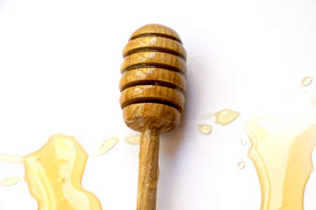 Wooden stick for honey drops of floral sweet honey top viewの写真素材