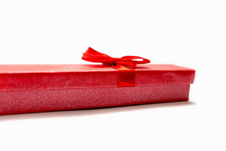 Isolated item red gift box with red ribbon for jewelry on white background.