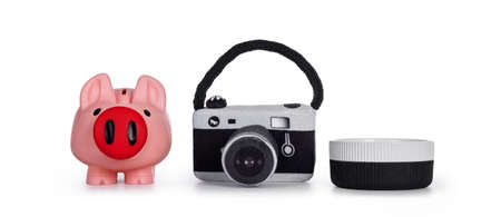 Piggy bank, toy photo camera and empty ceramic (food) on a row. Isolated on white background.の写真素材