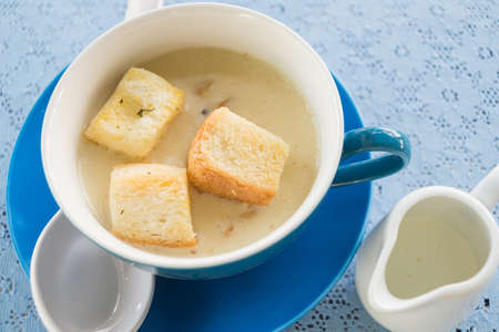 Mushroom soup and bread on top in blue cupの写真素材