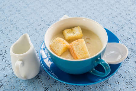 Mushroom soup and bread on top in blue cupの写真素材