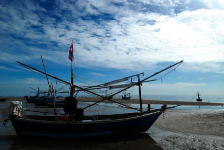 Thai fishing boat used as a vehicle for finding fish in the sea at sunsetの写真素材