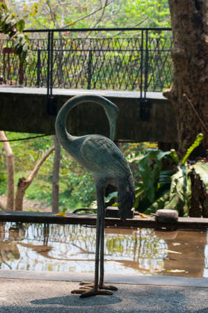 Bird statues placed beside a pond adorned by shooting against the light .の写真素材