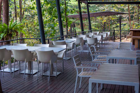 White tables and chairs in a restaurant in the forestの写真素材