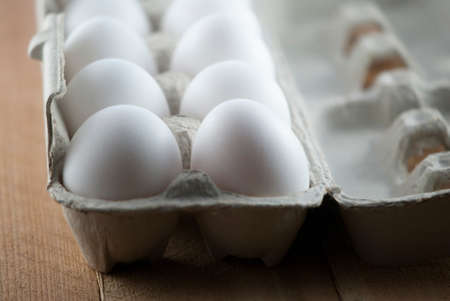Dozen White Eggs in Egg Carton on Wooden Table