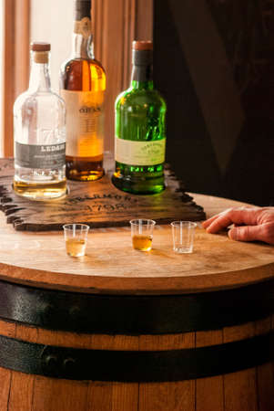 Scotch Tasting Bottles of Scotch with sample glasses atop a wooden barrelのeditorial素材
