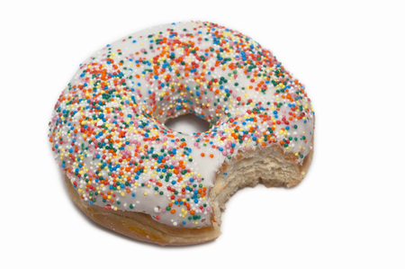 A vanilla doughnut with a bite taken outの写真素材