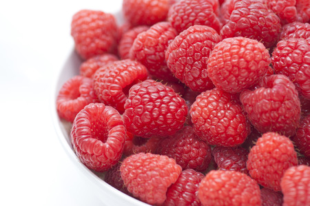 A close up of a bowl of red raspberriesの写真素材
