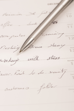 Close-up desk diary, schedule book, stress note, with a penの写真素材