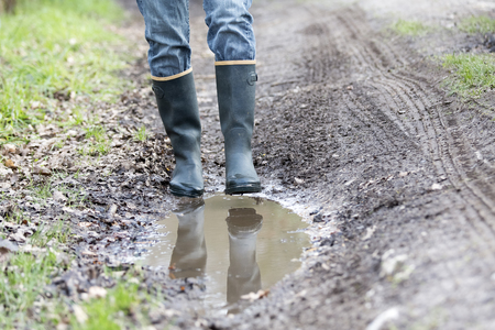 Man woman with rubber boots walking on rural path