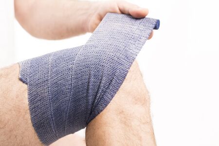 man putting  elastic bandage on knee pain health Franceの写真素材