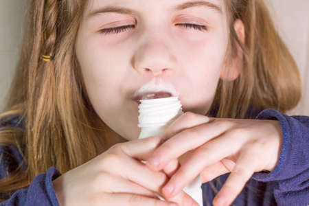 Close-up portrait of beautiful  little girl having breakfast, different feelings, food and drink concept, healthy food, indoorの写真素材
