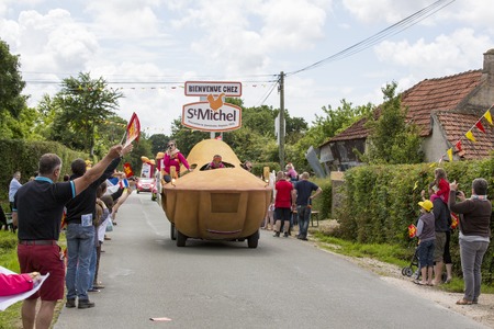 Documentary editorial. Hautteville Bocage, Manche, France - July 2 2016. First step of the French Cycle Tour, Cycle men and supporters along the road. Publicity cars before the cyclistsのeditorial素材