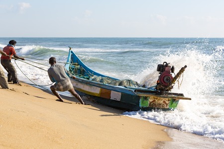 Pondichery, Tamil Nadu, India - February 27, 2014 : Traditional fishermen on beach, on sea, on sand. Long boats, Hard work poor peopleのeditorial素材