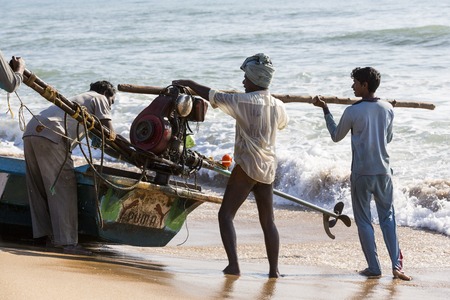 Pondichery, Tamil Nadu, India - February 27, 2014 : Traditional fishermen on beach, on sea, on sand. Long boats, Hard work poor peopleのeditorial素材