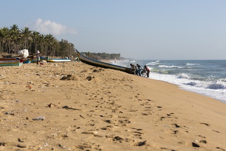 Pondichery, Tamil Nadu, India - February 27, 2014 : Traditional fishermen on beach, on sea, on sand. Long boats, Hard work poor peopleのeditorial素材