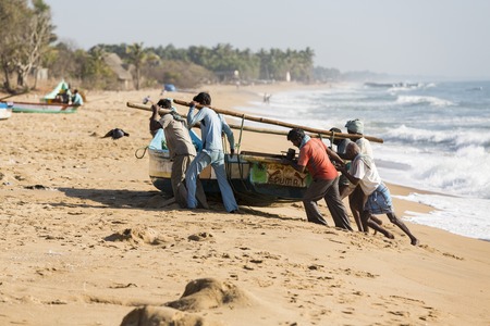 Pondichery, Tamil Nadu, India - February 27, 2014 : Traditional fishermen on beach, on sea, on sand. Long boats, Hard work poor peopleのeditorial素材