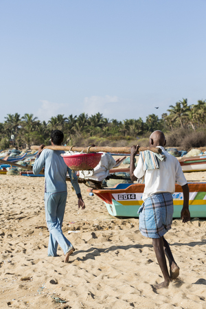 Pondichery, Tamil Nadu, India - February 27, 2014 : Traditional fishermen on beach, on sea, on sand. Long boats, Hard work poor peopleのeditorial素材