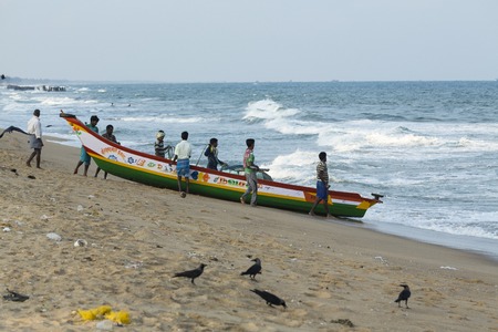 Pondichery, Tamil Nadu, India - February 27, 2014 : Traditional fishermen on beach, on sea, on sand. Long boats, Hard work poor peopleのeditorial素材
