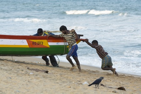 Pondichery, Tamil Nadu, India - February 27, 2014 : Traditional fishermen on beach, on sea, on sand. Long boats, Hard work poor peopleのeditorial素材