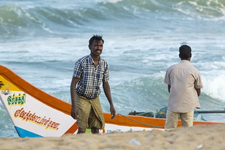 Pondichery, Tamil Nadu, India - February 27, 2014 : Traditional fishermen on beach, on sea, on sand. Long boats, Hard work poor peopleのeditorial素材
