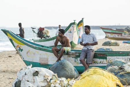 Pondichery, Tamil Nadu, India - February 27, 2014 : Traditional fishermen on beach, on sea, on sand. Long boats, Hard work poor peopleのeditorial素材