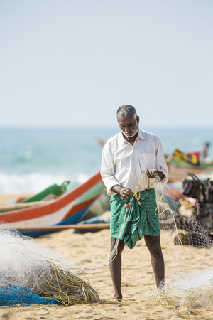Pondichery, Tamil Nadu, India - February 27, 2014 : Traditional fishermen on beach, on sea, on sand. Long boats, Hard work poor peopleのeditorial素材