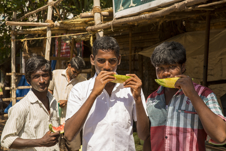 Illustrative image. Pondicherry, Tamil Nadu, India - February 25, 2014. Adolescents, young people in the street, eating shopping selling playingのeditorial素材
