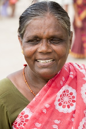 Illustrative image. Pondicherry, Tamil Nadu, India - April 14, 2014. Portrait of senior indian woman in traditional costume. Poor women sad smiling sittingのeditorial素材