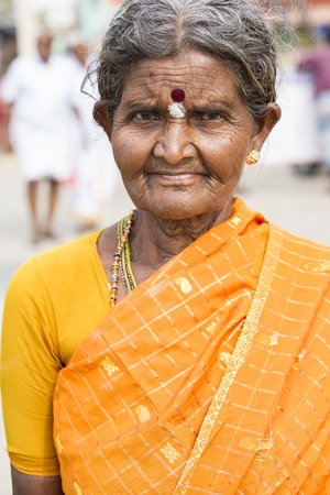 Illustrative image. Pondicherry, Tamil Nadu, India - April 14, 2014. Portrait of senior indian woman in traditional costume. Poor women sad smiling sittingのeditorial素材