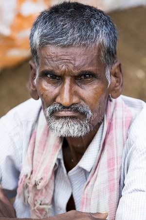 Illustrative image. Pondicherry, Tamil Nadu, India - April 14, 2014. Portrait of senior indian man in traditional costume. Poor men sad smiling sittingのeditorial素材