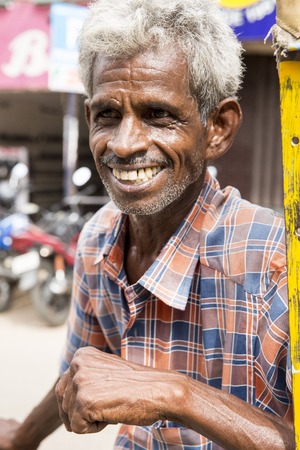 Illustrative image. Pondicherry, Tamil Nadu, India - April 14, 2014. Portrait of senior indian man in traditional costume. Poor men sad smiling sittingのeditorial素材