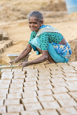 Illustrative image. Pondicherry, Tamil Nadu, India - July 03, 2014. Poor woman worker in small village, very hard work for little money roupiesのeditorial素材