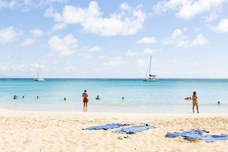 Les salines, Martinique - April 8, 2017. Tropical beach with with sand and blue sea, with people in and near the water.のeditorial素材