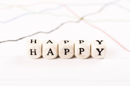 HAPPY written with wood cubes letters on financial business graphの写真素材