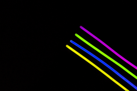 Glow sticks neon light fluorescent on back background. variation of different colored chem lights