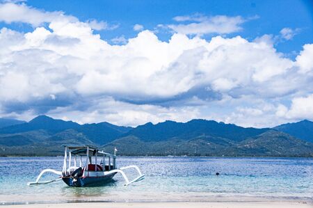 Traditional typical wood boat at Bali, indonesia, with blue seaの写真素材