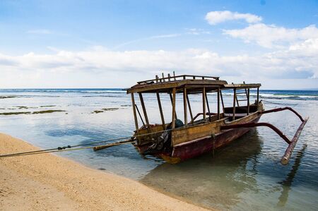 Traditional typical wood boat at Bali, indonesia, with blue seaの写真素材