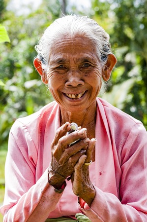 Ubud, Indonesia - July 28, 2013. An unidentified Balinese rice very old farmer poses during a morning's work near Ubud,のeditorial素材