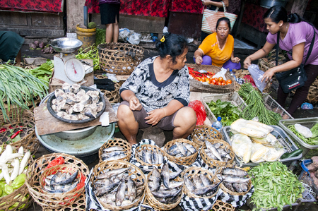 Ubud, Bali, Indonesia - August 01, 2013. Food fruits fishs and spices sale on the typical market by womanのeditorial素材