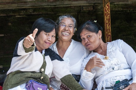 Bali, Indonesia - July 30, 2013. A few unidentified women preparing offerings and the ceremony in the hinduist buddhist Odalan temple.のeditorial素材