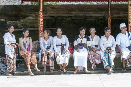 Bali, Indonesia - July 30, 2013. A few unidentified women preparing offerings and the ceremony in the hinduist buddhist Odalan temple.のeditorial素材