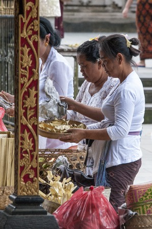 Bali, Indonesia - July 30, 2013. A few unidentified women preparing offerings and the ceremony in the hinduist buddhist Odalan temple.のeditorial素材